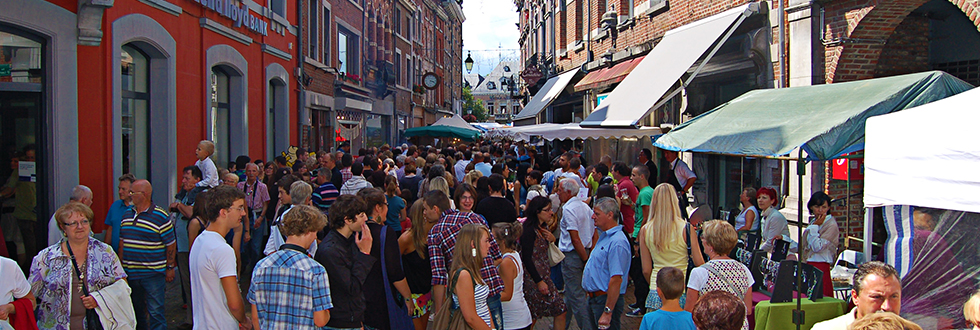 Drukke marktstraat vol bezoekers tussen de kraampjes