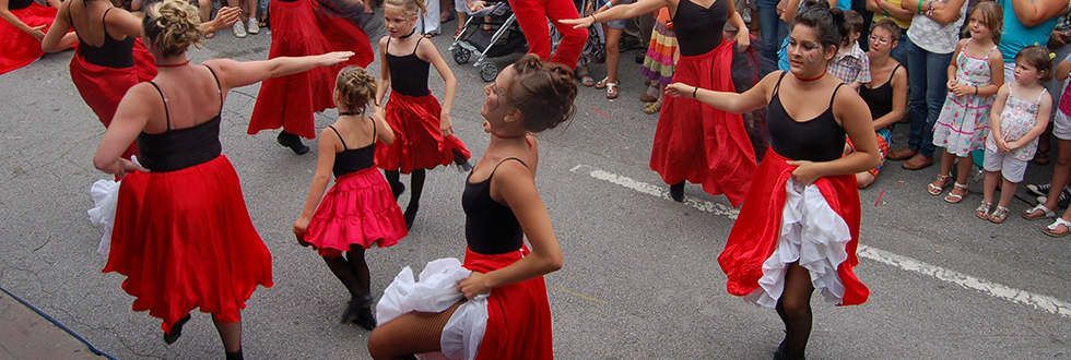 Dansgroep in rode en zwarte rokken danst op straat voor toeschouwers